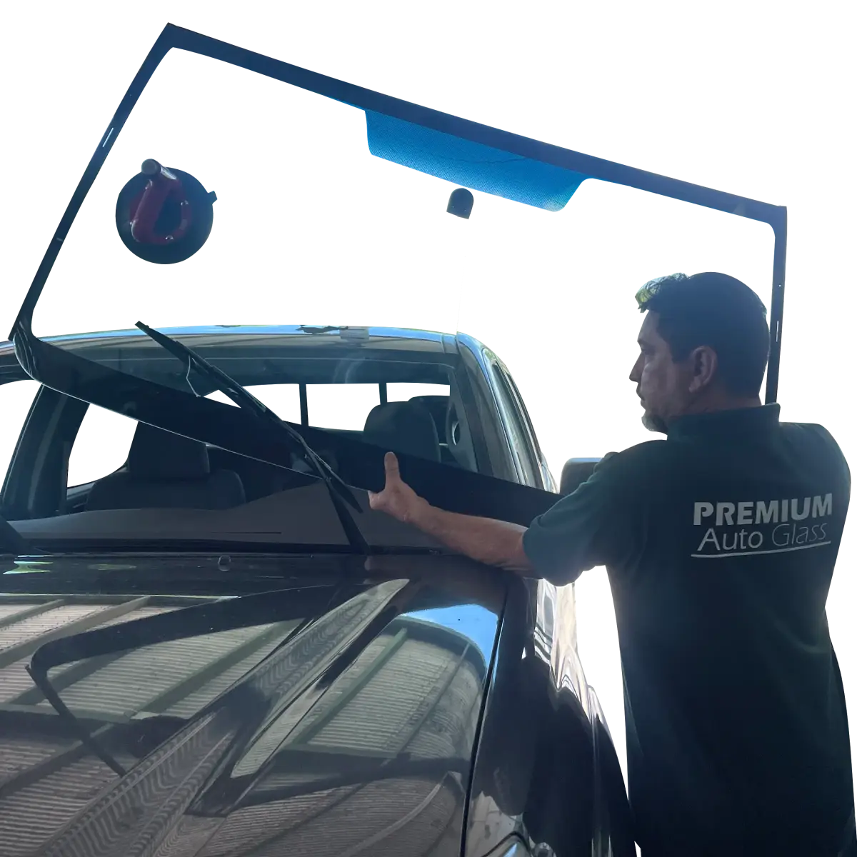 Auto glass installer holding windshield in front of a pickup truck.